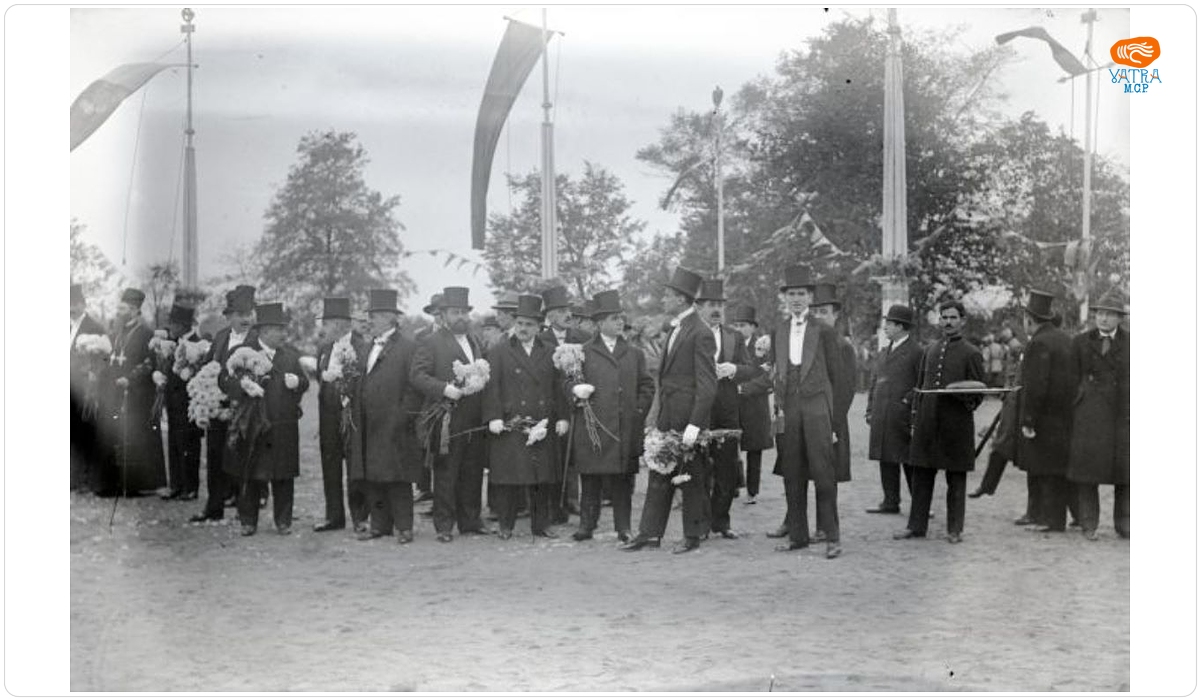 Grup de civili în ținută de gală și un preot, cu buchete de flori în mâini în așteptarea începerii ceremoniei Încoronării