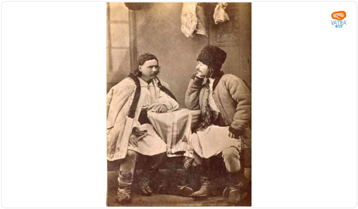 Doi bărbați îmbrăcați în costume populare de sărbătoare